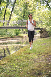 Geramny, Bayern, Bayreuth, Frau joggt am Fluss im Stadtpark - VTF000281