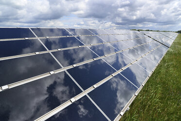 Deutschland, photoelektrische Zellen eines Solarkraftwerks mit Wolkenreflexionen, Teilansicht - LY000059