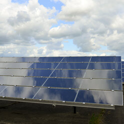 Deutschland, photoelektrische Zellen eines Solarkraftwerks mit Wolkenreflexionen, Teilansicht - LYF000064