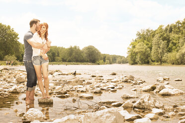 Germany, Bavaria, Munich, young couple standing at waterside of Flaucher, part of Isar River - FCF000237