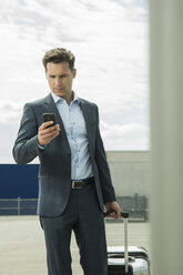 Portrait of business man looking at his smartphone - UUF000894