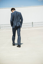 Business man walking on parking level, back view - UUF001005