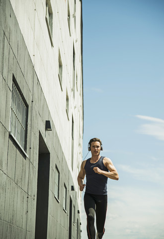 Mann mit Kopfhörern beim Joggen, lizenzfreies Stockfoto