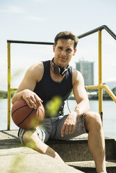 Portrait of man with headphones and basketball - UUF000930