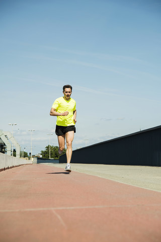 Mann joggt auf Brücke, lizenzfreies Stockfoto