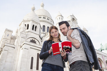 Frankreich, Paris, Porträt eines Paares mit Reiseführer vor der Sacre Coeur - FMKF001357