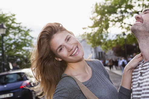 Frankreich, Paris, Porträt einer glücklichen jungen Frau, die sich mit ihrem Freund amüsiert - FMKF001266