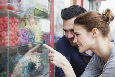 France, Paris, couple looking at sweets in a window display - FMKF001294