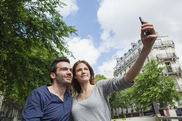 Frankreich, Paris, Pärchen fotografiert sich selbst mit Smartphone - FMKF001304