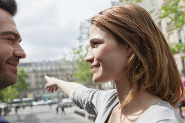 France, Paris, portrait of young woman showing her boyfriend the right direction - FMKF001305