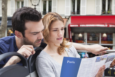France, Paris, couple looking at a city map - FMKF001306