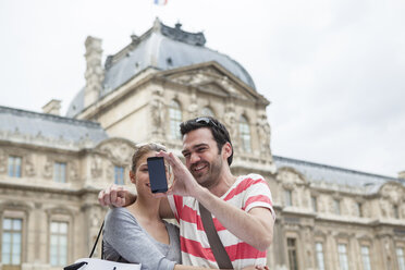 Frankreich, Paris, Pärchen fotografiert sich selbst mit Smartphone - FMKF001313