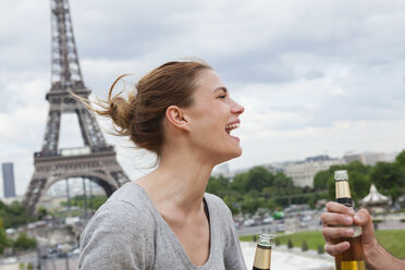 Frankreich, Paris, Porträt einer lachenden Frau vor dem Eiffelturm - FMKF001340