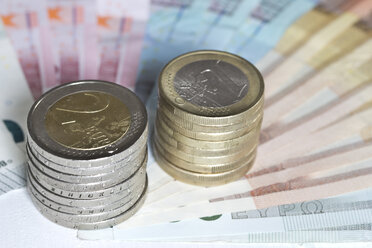 Sortierte Euro-Banknoten und Stapel von Ein- und Zwei-Euro-Münzen, Nahaufnahme - YFF000173