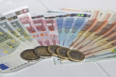 Sortierte Euro-Banknoten und fünf Ein- und Zwei-Euro-Münzen - YFF000174