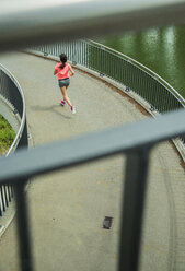 Junge Frau joggt auf einer Brücke, Rückenansicht - UUF000950