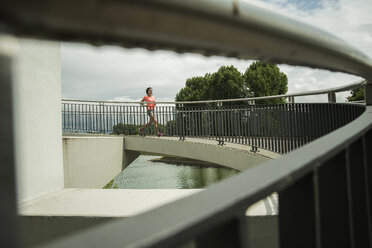 Junge Frau joggt auf einer Brücke - UUF000952