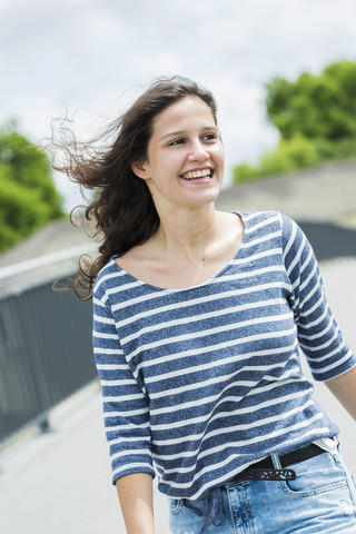 Porträt einer lächelnden jungen Frau mit wehendem Haar, lizenzfreies Stockfoto