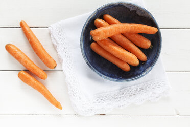 Bowl of carrots on cloth and white wood - EVGF000631