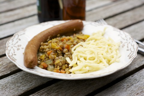 Linsen mit schwäbischen Nudeln, Spätzle und einer veganen Wurst, lizenzfreies Stockfoto