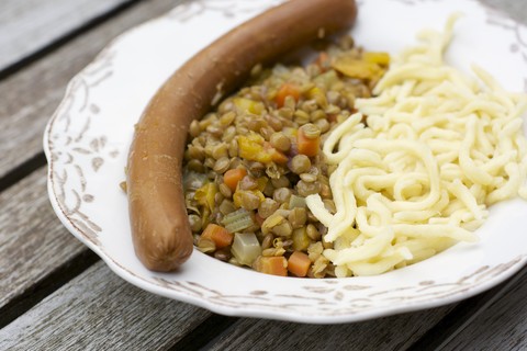 Linsen mit schwäbischen Nudeln, Spätzle und einer veganen Wurst, lizenzfreies Stockfoto