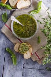 Fresh basil pesto in a glass and slices of baguette - ODF000702