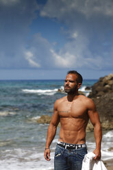 Greece, Ionic Islands, Corfu, shirtless man enjoying sunlight in front of the sea - AJF000068