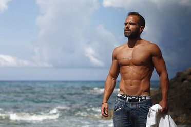 Greece, Ionic Islands, Corfu, shirtless man enjoying sunlight in front of the sea - AJF000069