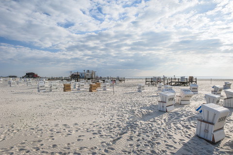 Deutschland,Schleswig-Holstein, Nordsee, Strand von Sankt Peter-Ording, Überdachte Strandkörbe, lizenzfreies Stockfoto