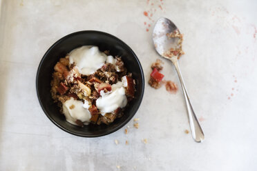 Rhabarber-Erdbeer-Crumble mit Joghurt in eine Schüssel geben, löffeln - EVGF000617