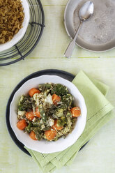 Bowl of vegetarian pistachio curry dish and a bowl of pilaf on wood, elevated view - EVGF000703