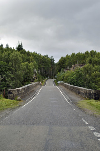 Vereinigtes Königreich, Schottland, Leere Straße in den Highlands, lizenzfreies Stockfoto