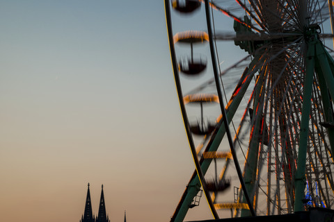 Germany, North Rhine-Westphalia, Cologne, Cologne cathedral and part of big wheel at sunset stock photo