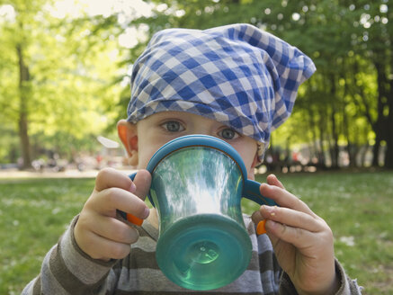 Baby boy wearing headscarf drinking - MUF001509