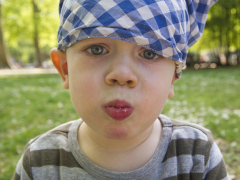 Kleiner Junge mit Kopftuch beim Essen, lizenzfreies Stockfoto