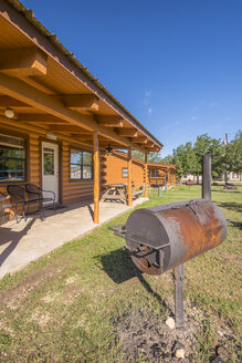USA, Texas, Blockhäuser mit BBQ-Smoker vor dem Haus - ABAF001353