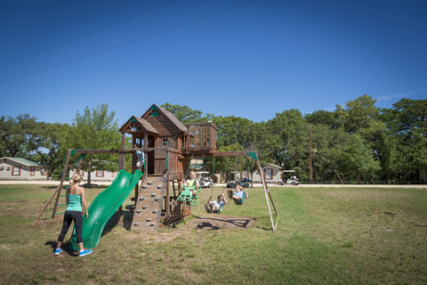 USA, Texas, Spielplatz mit Kindern und Mutter, lizenzfreies Stockfoto