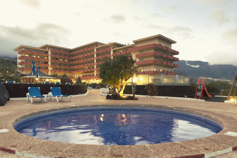 Spanien, Kanarische Inseln, La Palma, Schwimmbad mit Hotel im Hintergrund, lizenzfreies Stockfoto