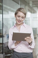 Deutschland, München, Geschäftsfrau im Büro, mit digitalem Tablet - RBYF000510
