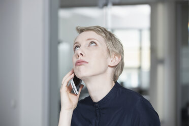 Deutschland, München, Geschäftsfrau im Büro, mit Smartphone - RBYF000531