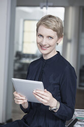 Germany, Munich, Businesswoman in office, using digital tablet - RBYF000532