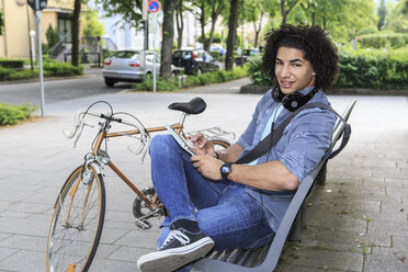 Junger männlicher Student mit Tablet-Computer und Rennrad - VTF000287