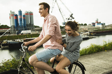 Junges Paar fährt zusammen auf dem Fahrrad - UUF001015