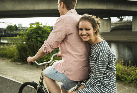 Young couple driving together on bicycle - UUF001016