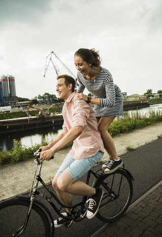 Junges Paar fährt zusammen auf dem Fahrrad, lizenzfreies Stockfoto