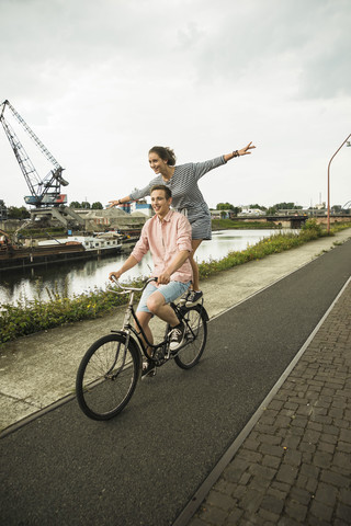 Junges Paar fährt zusammen auf dem Fahrrad, lizenzfreies Stockfoto