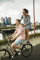 Junges Paar fährt zusammen auf dem Fahrrad - UUF001044