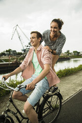 Junges Paar fährt zusammen auf dem Fahrrad - UUF001046