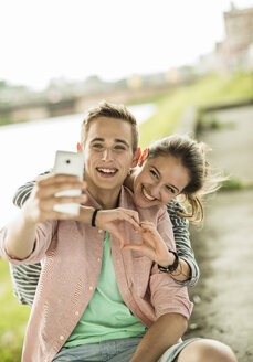 Glückliches junges Paar macht ein Selfie mit Smartphone - UUF001027