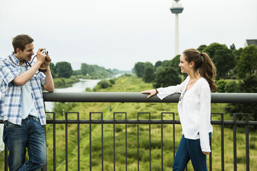 Young man photographing his girlfriend - UUF001084